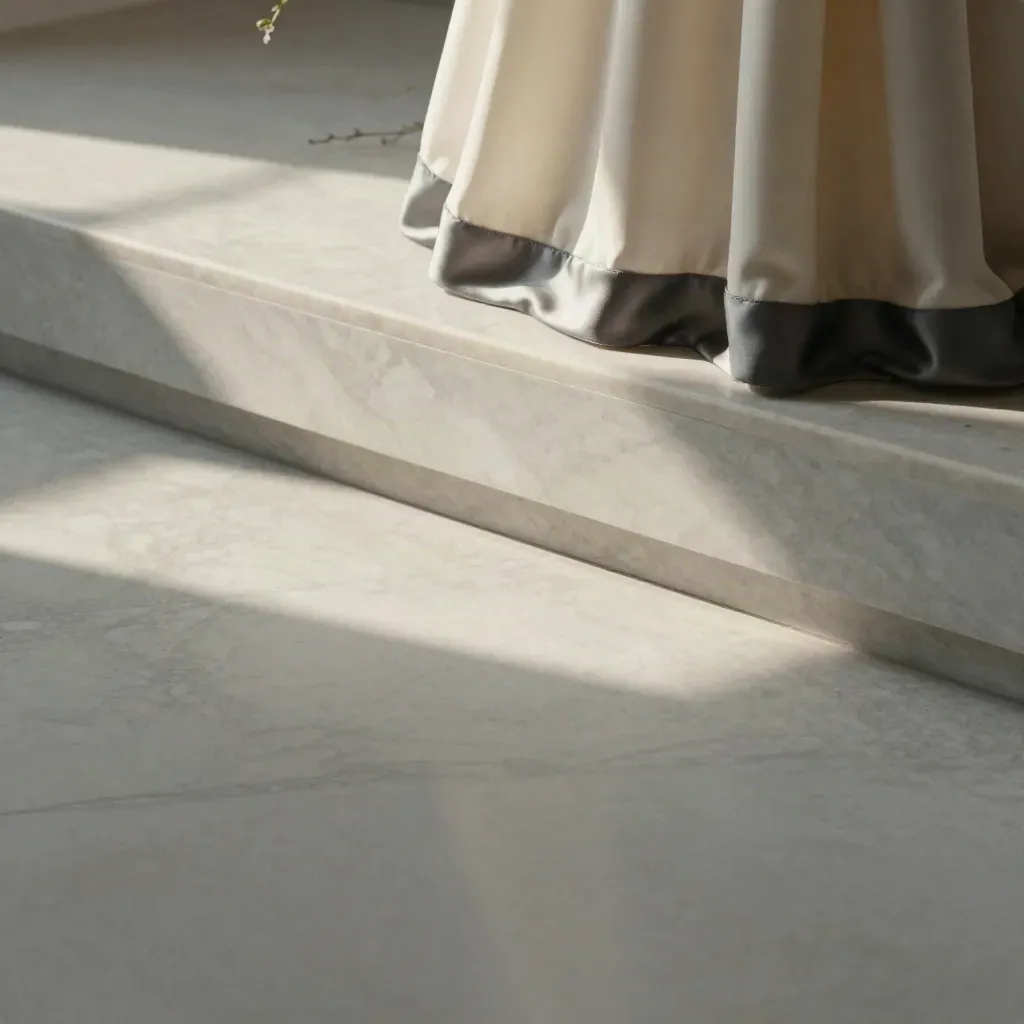 Pale marble ledge with a dress hem and floral stem, airy copy space below