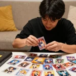 オリパおすすめのカードコレクションを楽しむ若者の姿、絵柄が鮮やかなトレーディングカードがパックから溢れ出す様子。